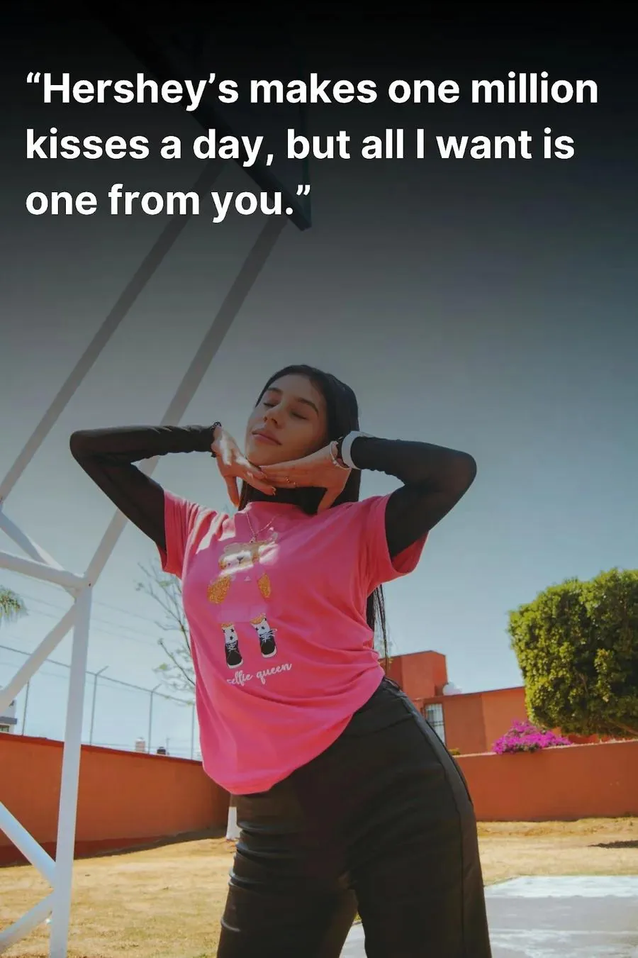 Young woman, on a basketball court, posing for the camera in a pink t-shirt