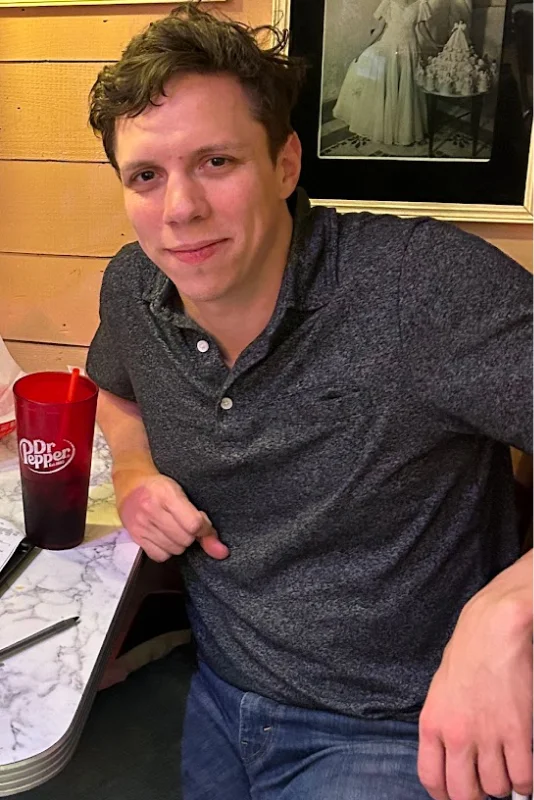 Unflattering photo for a dating app with distracting background and harsh shadows