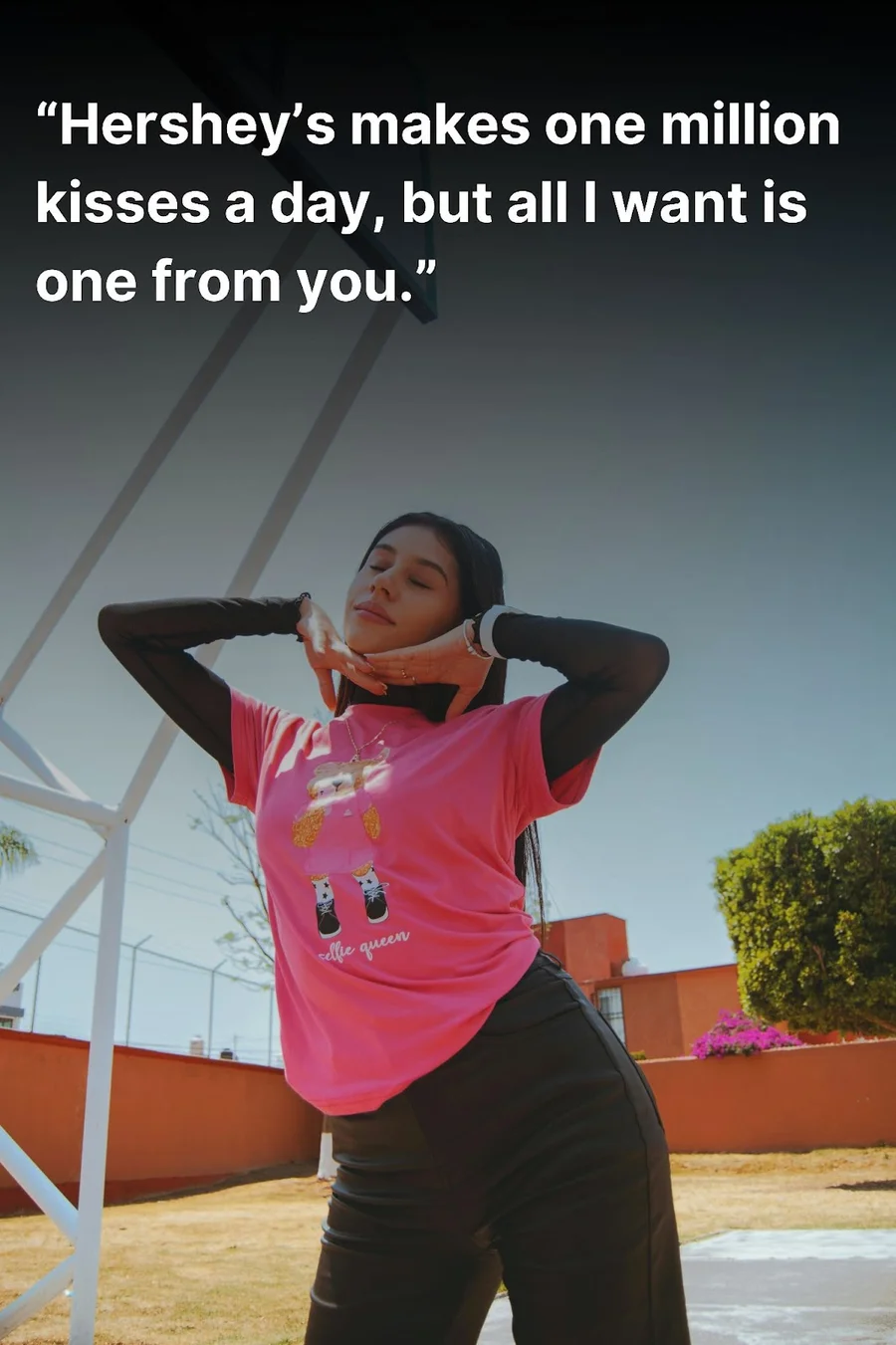 Young woman, on a basketball court, posing for the camera in a pink t-shirt