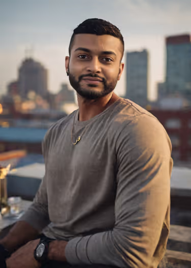 Ein bärtiger Mann sitzt selbstbewusst auf einem Felsvorsprung, perfekt für ein Profilfoto, um dein Tinder-Spiel zu verbessern