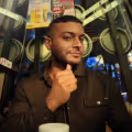 Ein Mann an einem Tisch mit einer Kaffeetasse, der vor der Erweiterung eine ungezwungene Atmosphäre für ein Dating-App-Profil zeigt