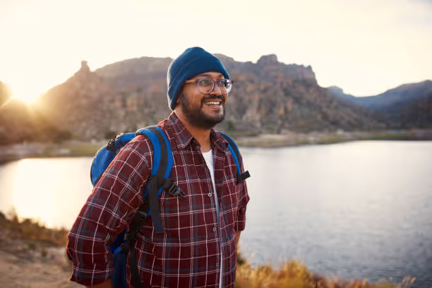 Man in a checkered shirt and green beanie taking a candid photo for good dating profile photo
